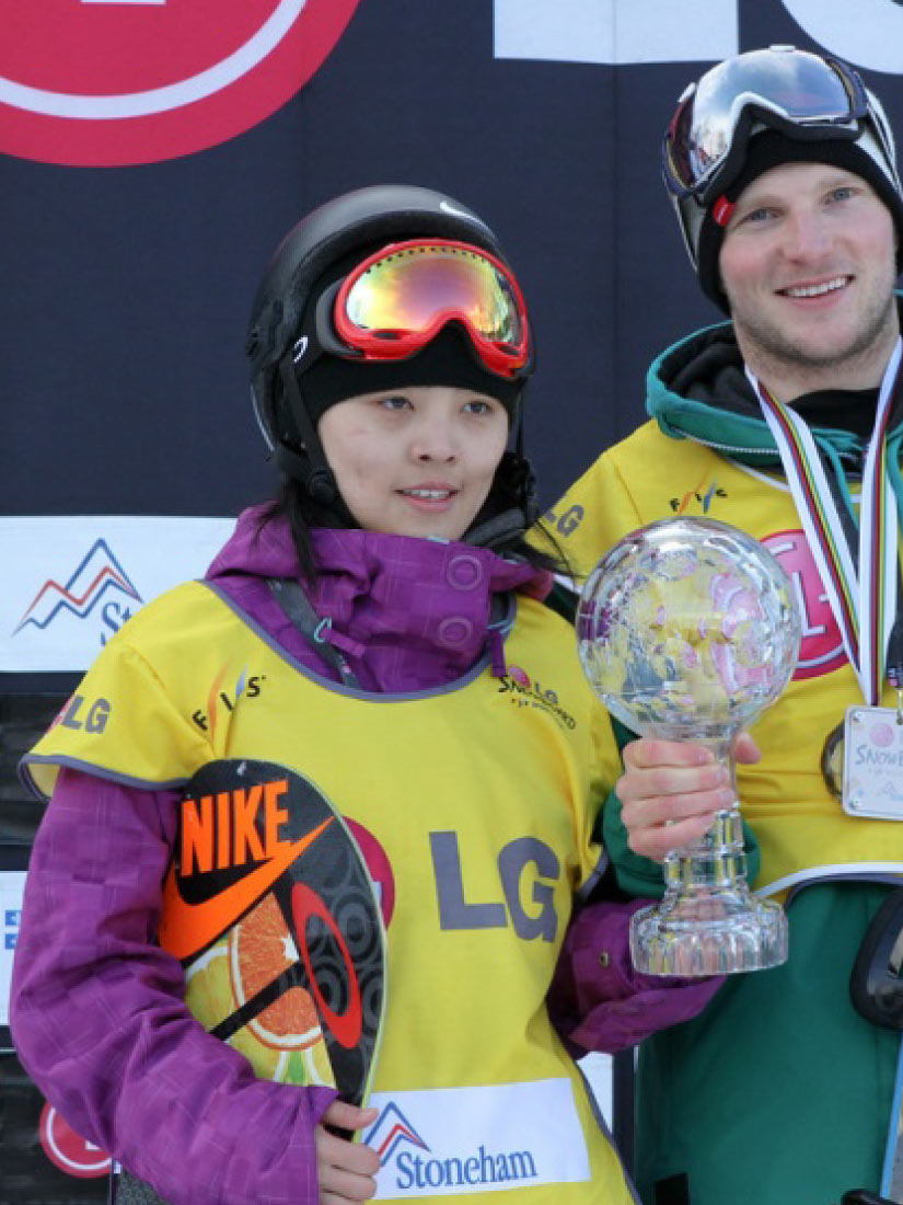 Athlètes de planche à neige demi-lune avec leur trophée portant le dossard de leader FIS jaune.
